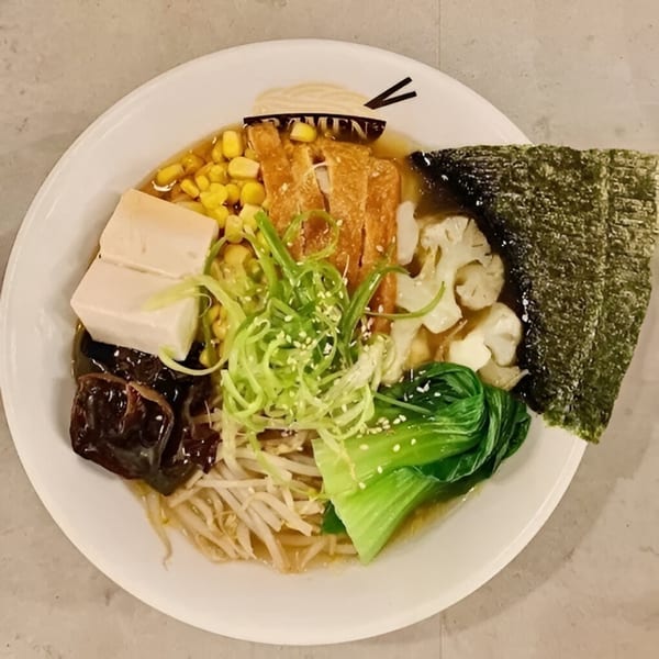 A bowl of Ramen Lab Eatery ramen with tofu, corn, bok choy, mushrooms, and nori.
