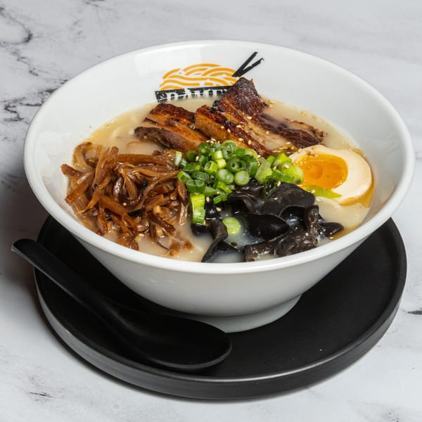 A bowl of Ramen Lab Eatery's ramen with pork belly, egg, mushrooms, and green onions.