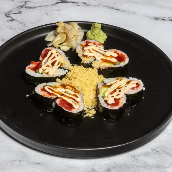 Heart-shaped sushi rolls with spicy tuna, sauce, and tempura flakes, served with ginger and wasabi.